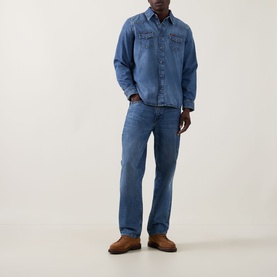 Model wearing Seven Jeans Western Denim Shirt in Canyon mid wash, paired with matching blue jeans and brown suede shoes