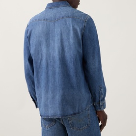 Model wearing Seven Jeans Western Denim Shirt in Canyon mid wash, rear view showing Western yoke detailing, tobacco stitching and long sleeves,