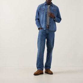 Model wearing Seven Jeans Western Denim Shirt in Canyon mid wash, styled with matching denim jeans, stripe tee and brown suede shoes.