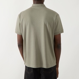 Model wearing Seven Jeans Regular Polo in army green, short sleeves, relaxed fit, back view, styled with dark jeans.
