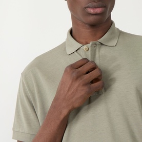 Model wearing Seven Jeans Army Regular Polo in sage green lyocell-cotton blend, close-up showing collar and button placket detail
