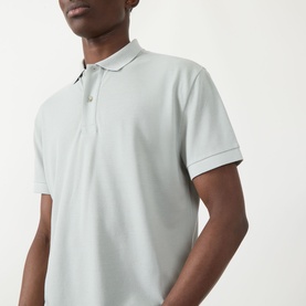 Model wearing Seven Jeans Regular Polo in Dusty Blue, short sleeves, ribbed collar and cuffs, relaxed fit piqu&eacute; fabric.