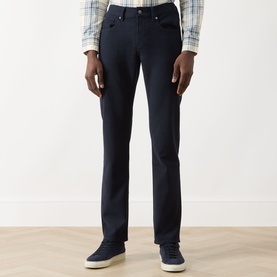 Model wearing Seven Jeans Ultramarine slim jeans, styled with a plaid shirt and navy suede trainers.