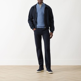 Model wearing Seven Jeans Ultramarine slim jeans, styled with a navy zip jacket, blue knit jumper and white trainers.