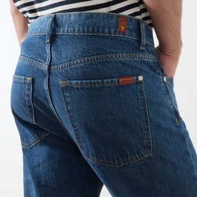 Model wearing Seven Jeans 3049 Straight Jeans in Kingfisher blue denim, showing rear pocket detail with branded tab
