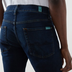 Model wearing Seven Jeans Straight 3049 Jeans in Indigo Minty, close-up of back pockets with teal branding detail