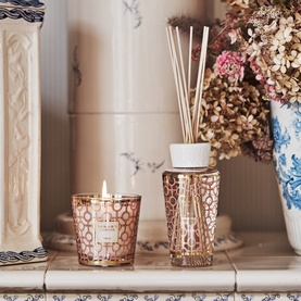 BAOBAB gift set featuring rose gold geometric patterned candle and reed diffuser with white cap, styled on marble shelf with dried flowers