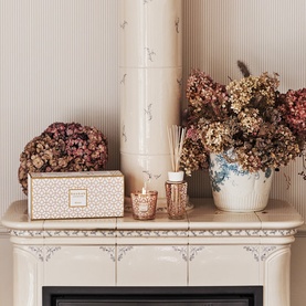 BAOBAB gift set styled on a cream fireplace mantel with dried florals, featuring a patterned box, reed diffuser, and candle in warm tones