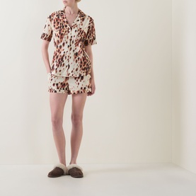 Model wearing Desmond & Dempsey Leopard Brown Top & Shorts Pyjama Set in cotton, styled with brown slippers.
