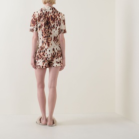 Model wearing Desmond & Dempsey Leopard Brown Top & Shorts Pyjama Set, back view, styled with white flat sandals.