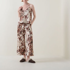 Model wearing Desmond & Dempsey Leopard Brown Cami & Wide-Leg Bottoms Pyjama Set; styled with dark brown slippers.