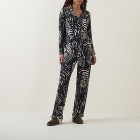 Model wearing Desmond & Dempsey black abstract print lyocell pyjama set with button-front top and straight-leg trousers
