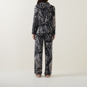 Model wearing Desmond & Dempsey black pyjamas with abstract zebra print, back view, long sleeve shirt and wide-leg trousers
