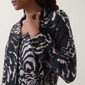 Model wearing Desmond & Dempsey black pyjama shirt in bold abstract print, close-up showing collar and long sleeve detail