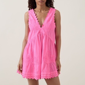 Model wearing Juliet Dunn hot pink cotton mini dress with V-neckline, lace trim detail and tiered silhouette