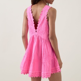 Model wearing Juliet Dunn hot pink cotton mini dress with deep V back, scalloped trim, lace inserts, and full tiered skirt.