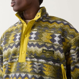 Model wearing Columbia Helvetia Half-Buttoned Logo Printed Fleece Sweatshirt in Mossy Green with zigzag print and snap-button funnel neck