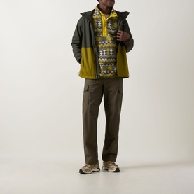 Model wearing Columbia Helvetia Half-Buttoned Logo Printed Fleece Sweatshirt in Mossy Green with dark jacket, khaki cargo trousers and trail trainers.
