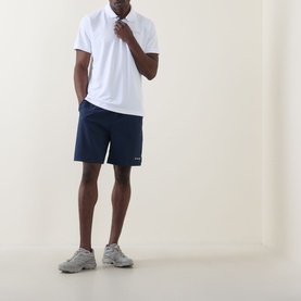 Model wearing Columbia Utilizer&trade; Logo Polo Shirt in white with navy shorts and grey trainers