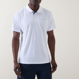 Model wearing Columbia Utilizer&trade; Logo Polo Shirt in White with contrast button placket, short sleeves and logo detail, styled with navy trousers.