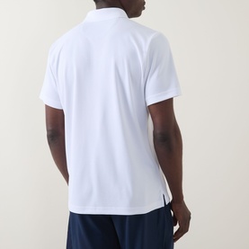 Model wearing Columbia Utilizer&trade; Logo Polo Shirt in White, rear view, short sleeves and straight hemline, paired with navy shorts.