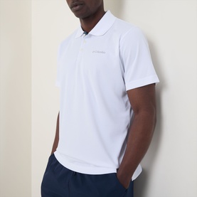 Model wearing Columbia Utilizer&trade; Logo Polo Shirt in white with contrast button placket, styled with navy trousers.