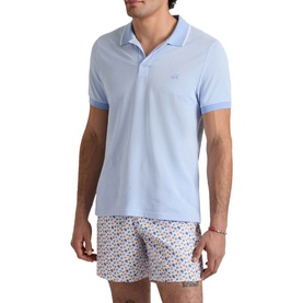 Model wearing Vilebrequin Regular Polo in cloudy blue with white tipped collar and cuffs, styled with printed swim shorts.