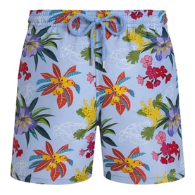 Vilebrequin swim shorts in Fleur de Lin with vibrant tropical floral print in red, yellow and purple on a light blue background