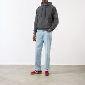Model wearing Edwin Axiom Logo Hoodie in dark grey with light wash straight jeans and red Adidas Samba trainers.