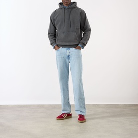 Model wearing Edwin Axiom Logo Hoodie in dark grey with light wash straight-leg jeans and red suede trainers.