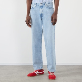 Model wearing Edwin Loose Straight Leg Jeans in light used blue denim, styled with red Nike trainers and a striped top.