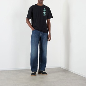 Model wearing Edwin Tyrell High-Rise Straight Leg Jeans in blue nix wash with black graphic tee and dark trainers.