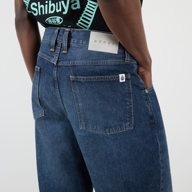 Model wearing Edwin Tyrell High-Rise Straight Leg Jeans in blue nix wash, showing rear view with logo badge and tobacco stitching detail.