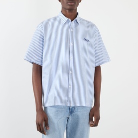 Model wearing Edwin Toledo Stripe Shirt in blue and white vertical stripes, short sleeves, embroidered logo, styled with light blue jeans.