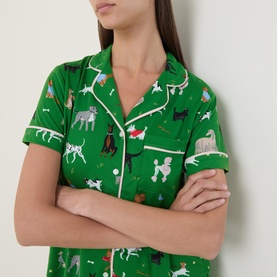 Model wearing Kate Spade Dog Park pyjama shirt in green with multicolour dog print and cream piping, short-sleeved with lapel collar