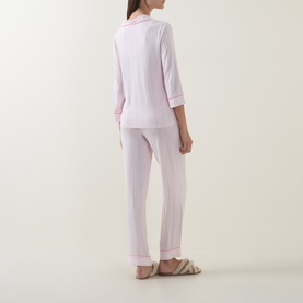 Model wearing Kate Spade Christy Shirting Stripe pyjamas in pink and white, rear view, with 3/4-length sleeves and full-length trousers.