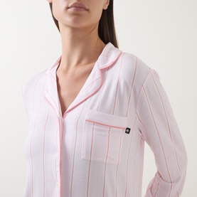 Model wearing Kate Spade pyjama top in Christy Shirting Stripe, pink and white vertical stripes with contrast piping and chest pocket.