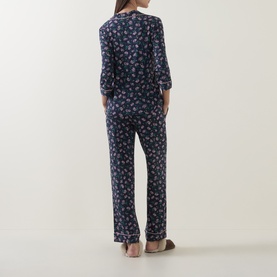 Model wearing Kate Spade Lively Blooms Tossed pyjamas in navy floral print, shown from behind, with long sleeves and full-length trousers.