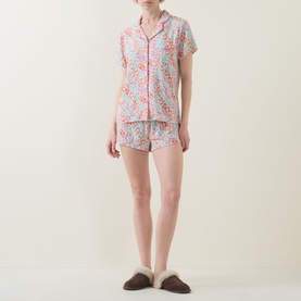 Model wearing Stripe & Stare Sweet Posy Short Pyjama Set in floral print with notched lapels, piped trim, and matching shorts, styled with fluffy