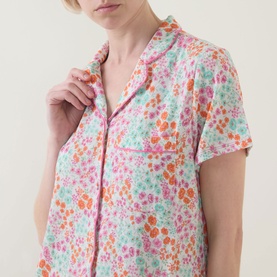 Model wearing Stripe & Stare Sweet Posy Short Pyjama Set in floral print, showing notched lapel collar, short sleeves and chest pocket detail.