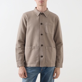 Model wearing Nudie Jeans Barney Worker Overshirt in Mud, button-front with chest pocket and patch pockets, styled with blue jeans