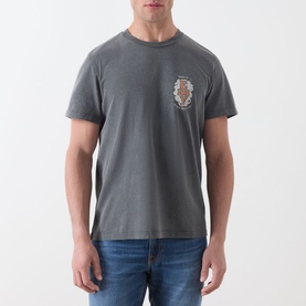 Model wearing Nudie Jeans Roy Take It Easy Logo T-Shirt in Antracite, crew neck with chest logo graphic, styled with blue jeans.