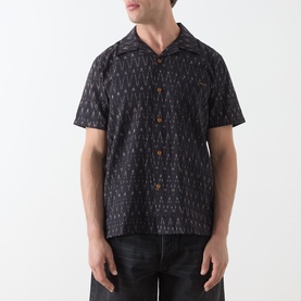 Model wearing Nudie Jeans Reg Shirt in R22 Multi, short-sleeve camp collar with all-over geometric print, styled with dark jeans