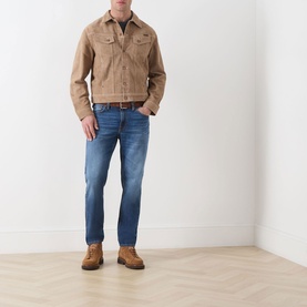 Model wearing Nudie Jeans Gritty Jackson Straight-Leg Jeans in Sun Set, mid-rise straight fit with faded wash, styled with tan jacket and brown boots