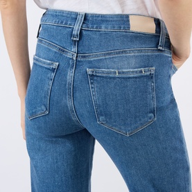 Model wearing Paige Mason Mid-Rise Ankle Straight Leg Jeans in Monaco Mist, rear view showing five-pocket style and logo badge detail.