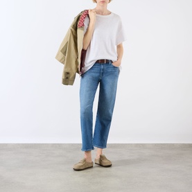 Model wearing Paige Mason Mid-Rise Ankle Straight Leg Jeans in Monaco Mist with white tee, loafers, and tan jacket draped over shoulder.