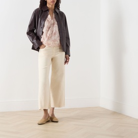 Model wearing Paige Anessa Front Pockets High-Rise Wide Leg Jeans in Butter Yellow, styled with a dark leather jacket and pink blouse.
