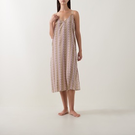 Model wearing DKNY Dusky Green Logo Stripe Chemise, midi-length slip dress with thin straps and all-over print, bare feet