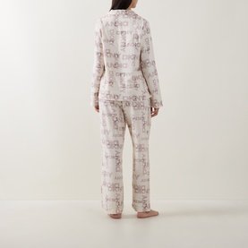 Model wearing DKNY Blonde Logo Plaid pyjamas, rear view, long-sleeve shirt and wide-leg trousers in all-over print.