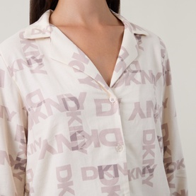 Model wearing DKNY Pyjamas in Blonde Logo Plaid, close-up of notch collar shirt with allover DKNY logo print